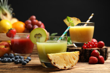Delicious colorful juices in glasses and fresh ingredients on wooden table