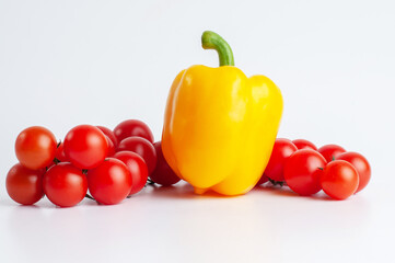 Photo of a yellow pepper and two tomatoes twig