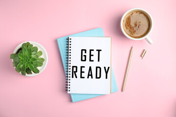 Notebook with text Get Ready, pen, cup of coffee and houseplant on pink background, flat lay