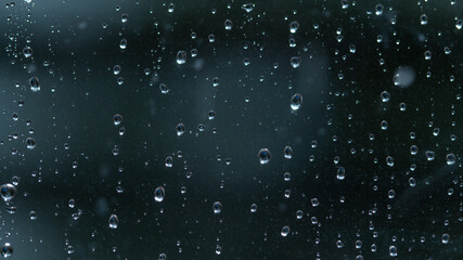 Naklejka na ściany i meble MACRO: Clear raindrops accumulate on the windowpane during a severe rainstorm.