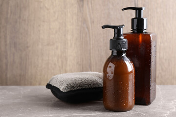 Dispenser bottles with water drops and bast wisp on beige marble table, space for text. Men's...