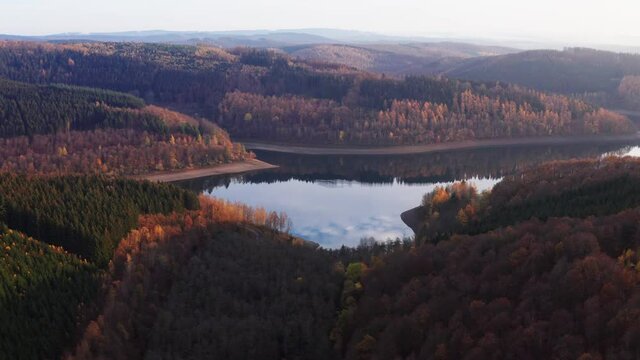 
the obernau reservoir with the rothaar mountains in germany in autumn