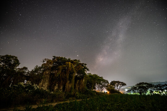 
Night landscape of an old church eaten by the jungle, in the background you can see the amazing night sky, with the Milky Way rising on the horizon and the stars guarding it.