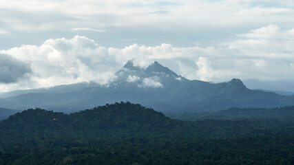 Victoria Peak towering above misty mountain ridges and forested slopes under a cloudy sky in Belize.