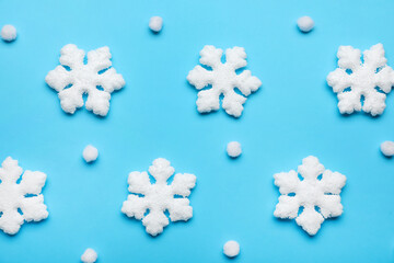 Beautiful decorative snowflakes on light blue background, flat lay