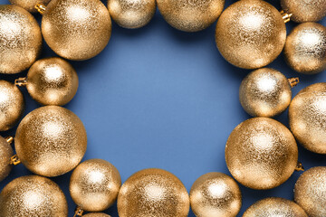 Frame of shiny Christmas balls on blue background, flat lay. Space for text