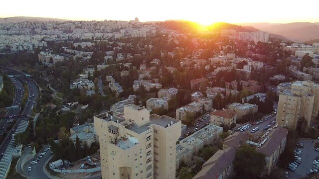 Wide aerial, sun sets over Jerusalem skyline
