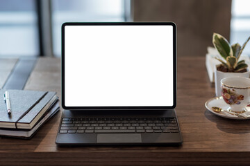 Mock up. blank screen digital tablet with office supplies on wooden table.