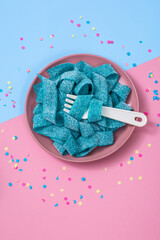 Blue chewable candy gums on pink and blue background. Flat lay, top view. - 392990257