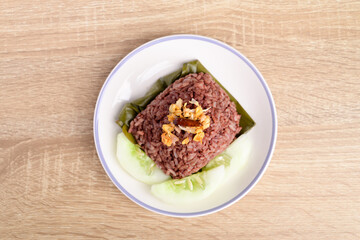 Northern Thai food (Khao Kan Chin or Khao Ngiao), Steamed rice mixed with pork blood eating with fried chopped garlic, fried chili and fresh cucumber