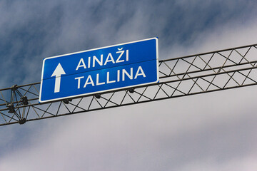 Blue metallic road sign direction to Ainazi and Tallinn, Estonia.