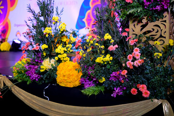 Colorful flowers with leaves ornamented a stage for Indian festival