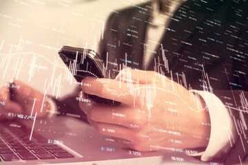 Multi exposure of man's hands holding and using a digital phone and forex graph drawing. Financial market concept.