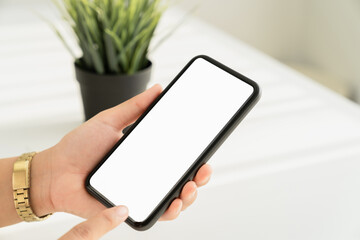 Woman hand holding smartphone and the screen is blank, social network concept, copy space for your advertising.