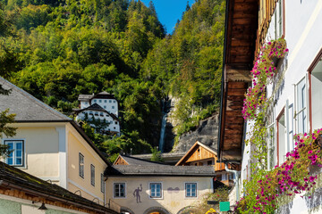 Fototapeta na wymiar Hallstatt at the Hallstädter See with traditional houses and waterfall over the village, region of Salzkammergut, Austria