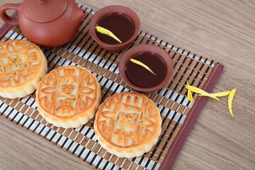 Three moon cakes for the Mid-Autumn Festival and tea in a purple sand tea set