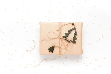 Gift box wrapped in craft paper with decor on white background