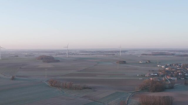 Pastel spring sunrise over windmill farm.