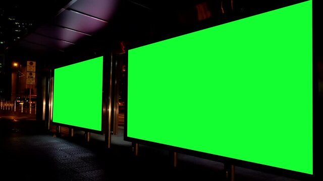 Night city street billboard stand with green screen. Green screen for text or copy.