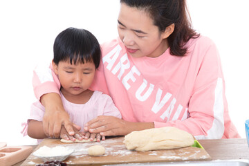 Young Chinese mother teaches her children how to make mooncakes