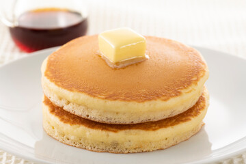 積み重ねたホットケーキにメープルシロップをかけて食べる