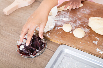 On the cutting board in the kitchen, my mother is teaching her children to make mooncakes by hand