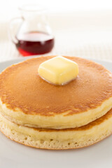 積み重ねたホットケーキにメープルシロップをかけて食べる