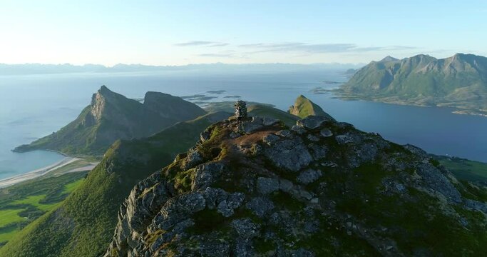 Male hiker on arctic mountain top with spectacular view of Norwegian coast