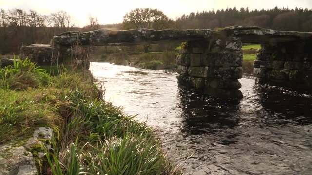 View of bridges of rough stone in the middle of the national park in the  English country side with a stream under it. Postbridge Dartmoor, Devon.