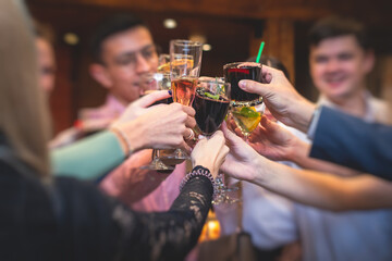 People celebrate and raise glasses, cheering with alcohol glasses with wine and champagne in the restaurant on corporate christmas birthday party event or wedding celebration