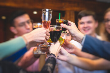 People celebrate and raise glasses, cheering with alcohol glasses with wine and champagne in the restaurant on corporate christmas birthday party event or wedding celebration