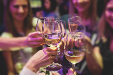 People celebrate and raise glasses, cheering with alcohol glasses with wine and champagne in the restaurant on corporate christmas birthday party event or wedding celebration