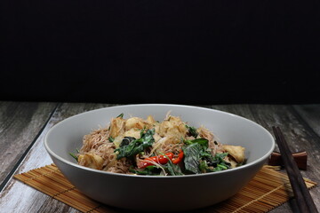 Fried and stirred spicy rice noodle with fresh basil, chilly and shrimp meat ball on the plate. Famous traditional street food menu in Asia restaurant. 