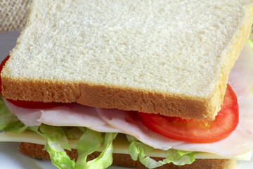 sandwich au jambon et crudités sur une assiette