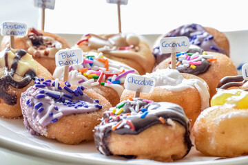 Colorful Assorted Donuts on white plate, Extreme Close up