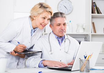 Doctor and nurse reading patient information in hospital computer database