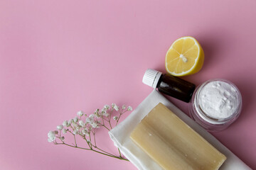 Natural cleaning products are laid out on a pink background. Lemon, soda, linen towel, natural soap,  flowers in a beautiful glass for comfort.