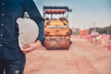 Close up hand holding helmet hard hat Engineering concept, Worker Engineer Standing on road site construction