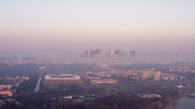 Warsaw skyline in the first morning light just above the fog. Drone shoot over the smog.
