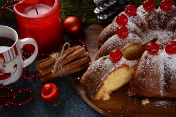 Obraz na płótnie Canvas Christmas and New Year concept. Delicious lemon cake with red sweet cherries and sugar powder.