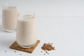 Buckwheat seeds and glass of gluten-free milk which is source of protein, amino acids, manganese...