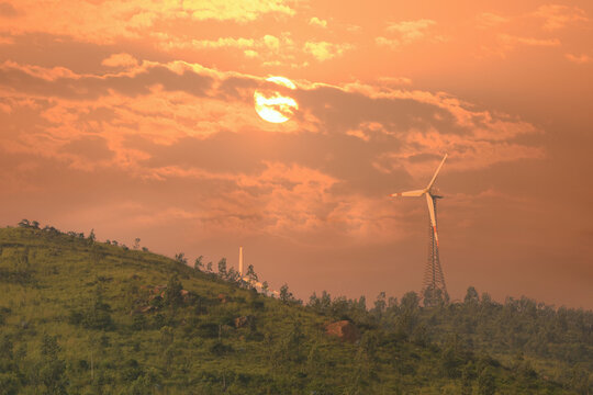 Beautiful HDR Image of sunrise above the windmills over mountain and fields.
