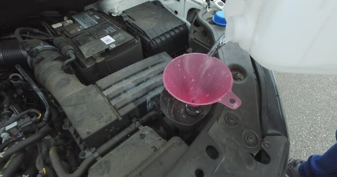 Pouring exhaust additives for diesel engines into the tank for ad Blue, mixture of urea and deionized water.