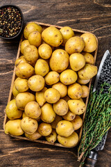 Young whole baby Potatoes in a wooden tray. Wooden background. Top view