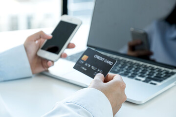 Businesswoman hand holding and use credit card to online shopping from home with laptop, payment e-commerce, internet banking, spending money for next holidays