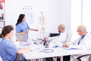 Fototapeta premium Team of doctors in hospital office setting diagnostic in hospital conference room. Clinic expert therapist talking with colleagues about disease, medicine professional.