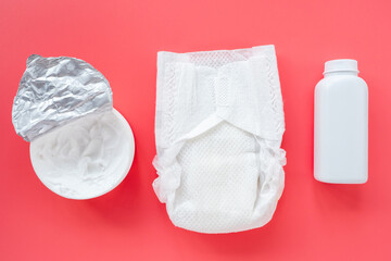 Obraz premium Composition with baby accessories and cosmetics for child care on a pink background, flat flat, top view, layout. Trendy background, hygiene of newborn girls