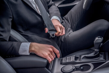 Close-up of driver's hands fastening seat belt