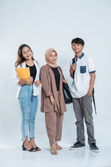 Portrait of Happy College Friends carrying a bag and book on an isolated white