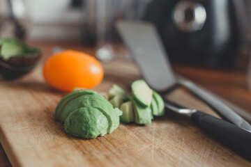 Pieces of avocado and tomato vegetables on a cutting wooden board